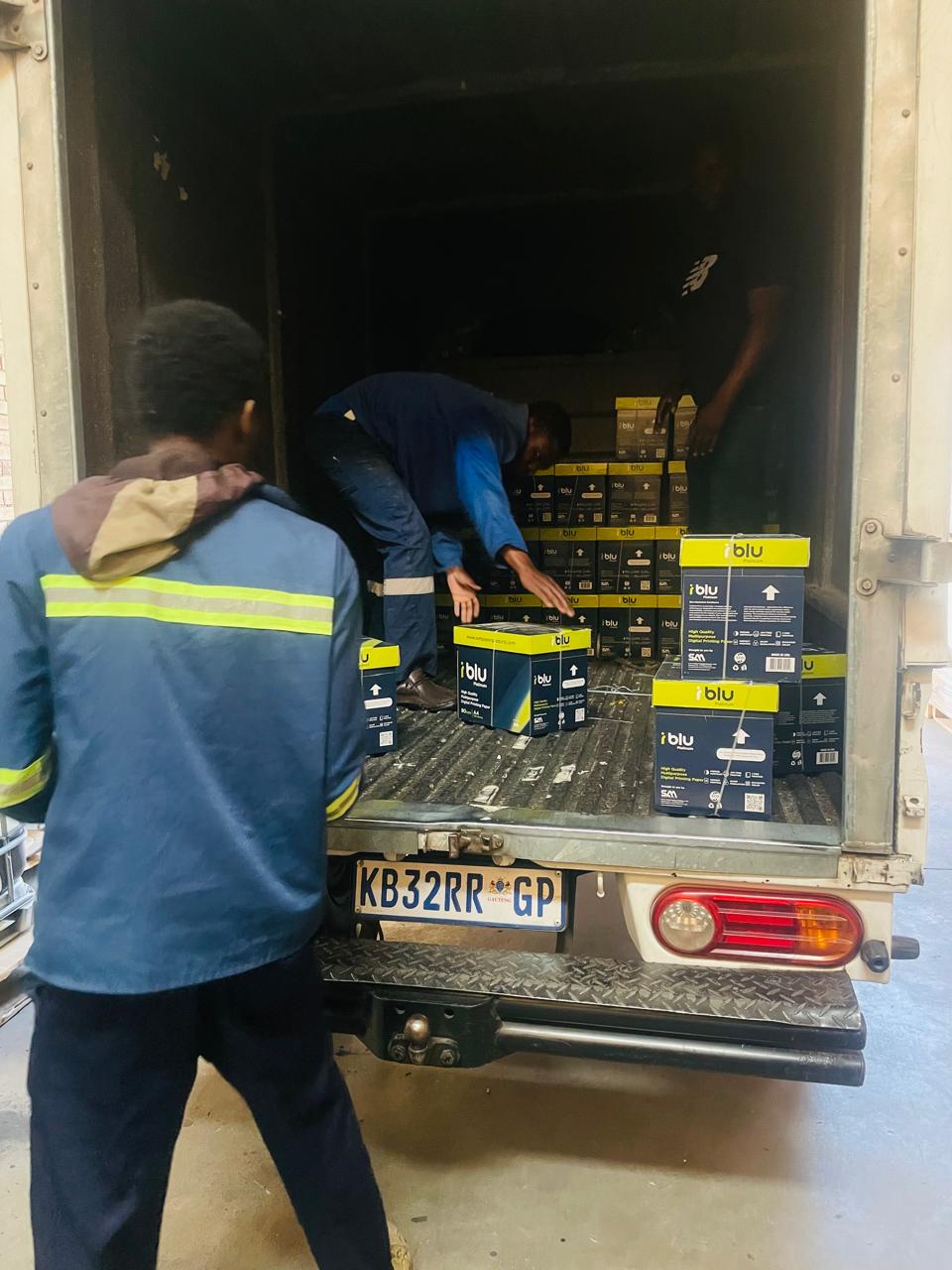 Team members loading boxed supplies into a delivery vehicle
